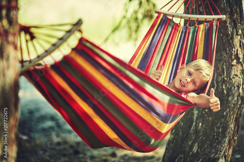 Little boy resting in hammock outdoors. Summer camp