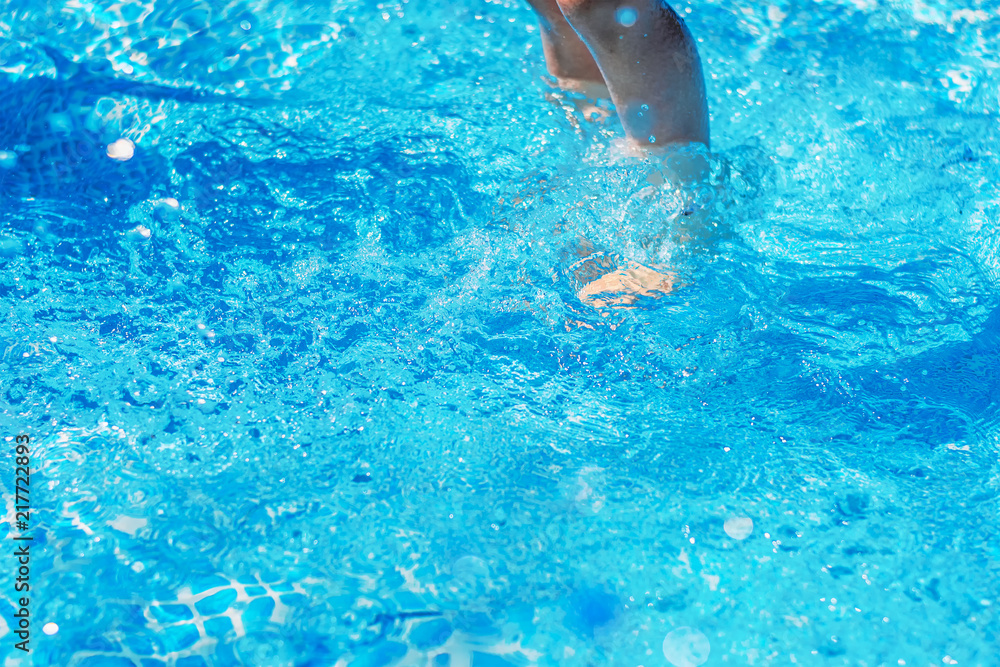 Legs under water in blue pool closeup