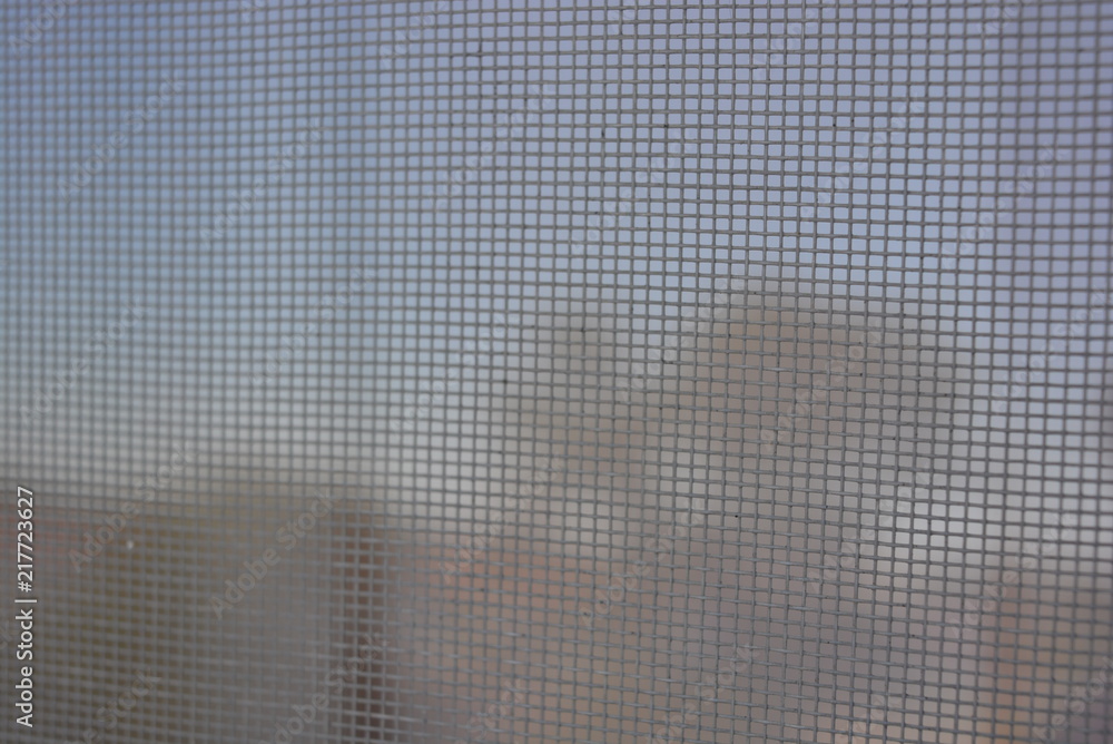 White small mosquito net against flies on a white metaloplastic window White small mosquito net against flies on a white metaloplastic window