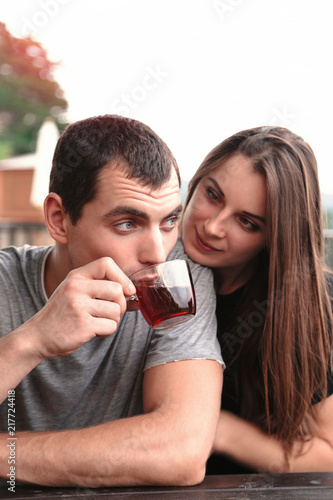 Young beautiful couple share tea at garden table