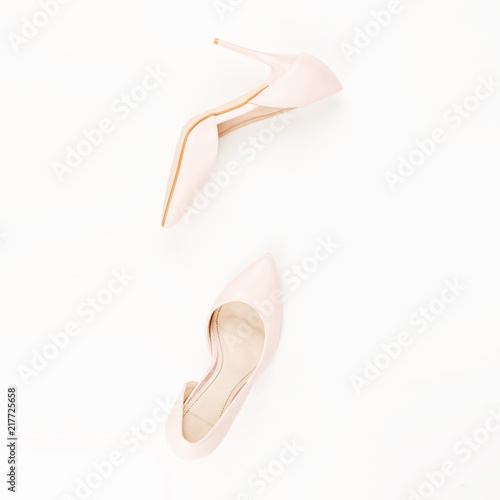 Woman pale pink pumps on pink and white background. Top view, copy space, minimal background. Fashion concept