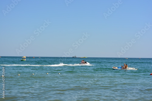 Blue sky with blue smooth sea of the black sea with catamarans and a water motorcycle