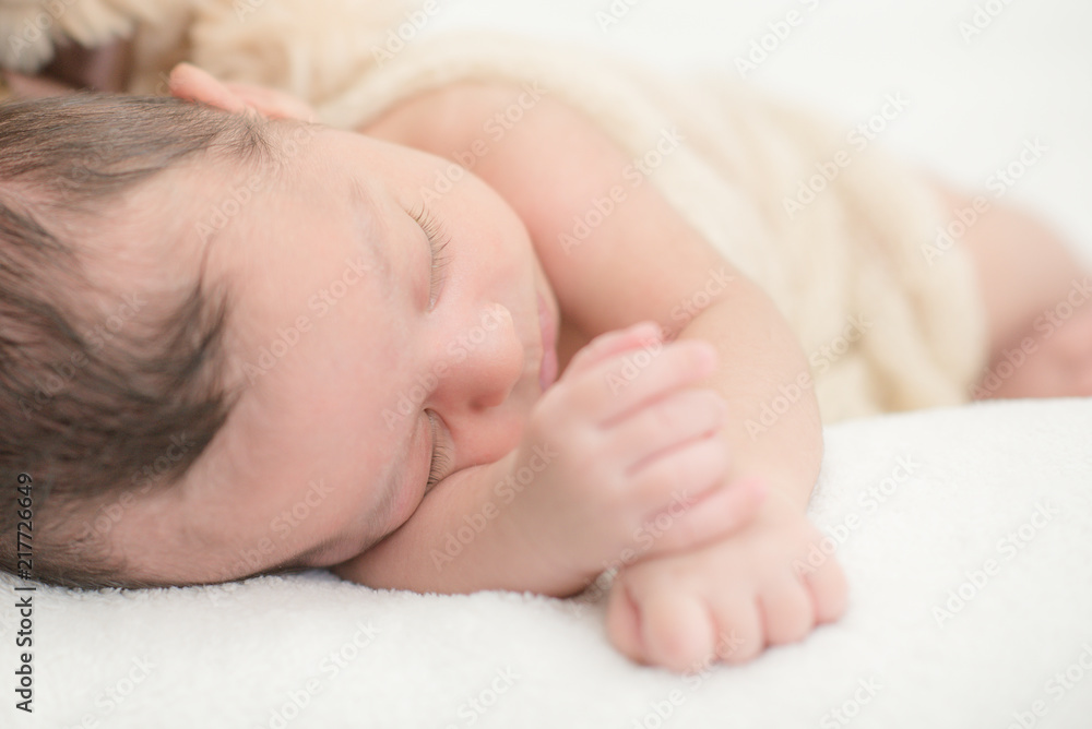 Cute newborn baby sleeping on a blanket - happy family moments concept Cute newborn baby sleeping on a blanket - happy family moments concept