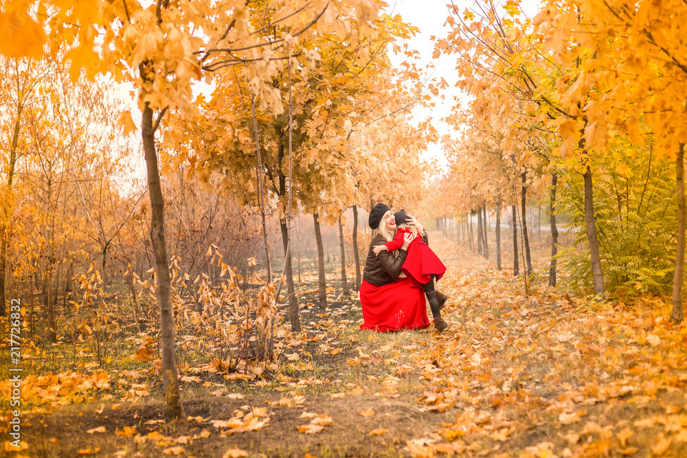 beautiful mother and daughter on a background of autumn garden gently embrace each other beautiful mother and daughter on a background of autumn garden gently embrace each other