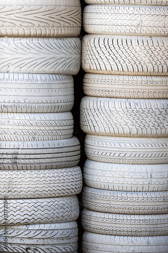 White tires. Stack of car tyres painted white. Automobile background image.
