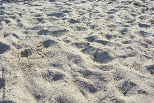 Yellow sand with shallow shell and depressions on the Black Sea beach at the Iron Port during the day
