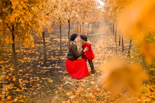 young mother plays with her little daughter in the autumn garden photo