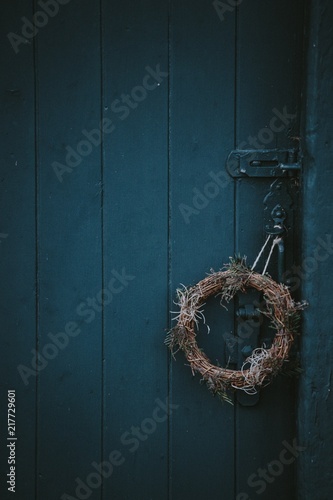 Festive holiday wreath hanging on a door photo