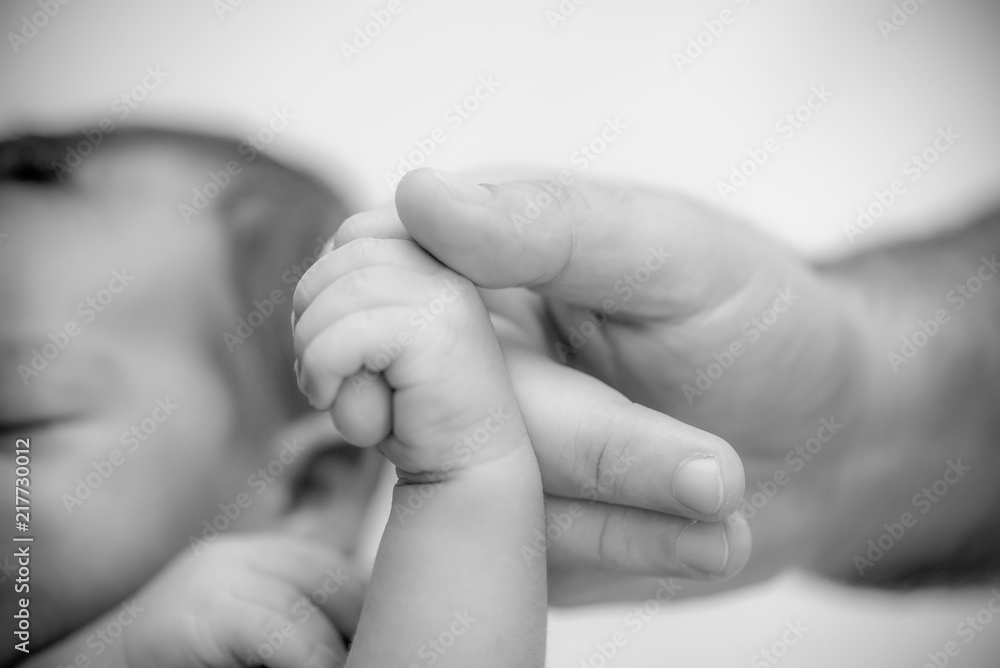 Newborn baby holding finger of mother / father. Happy Family and Baby protection concept. Mom and dad holding the hand of their child. Newborn baby holding finger of mother / father. Happy Family and Baby protection concept. Mom and dad holding the hand of their child.