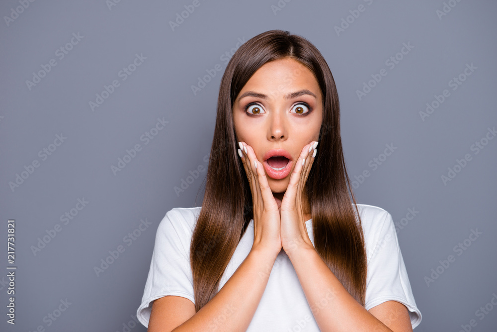 NO WAY! Close up portrait of frustrated girl with wide open eyes mouth holding palms near cheeks looking at camera isolated on gray background NO WAY! Close up portrait of frustrated girl with wide open eyes mouth holding palms near cheeks looking at camera isolated on gray background