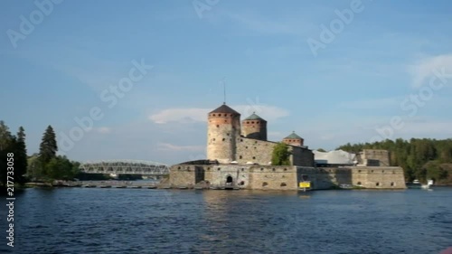 View of Medieval Castle Olavinlinna in Savonlinna from Boat with Flag of Finland off Back photo