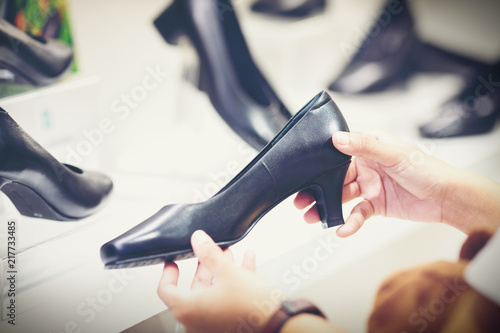 hand of customer choosing shoes in luxury store