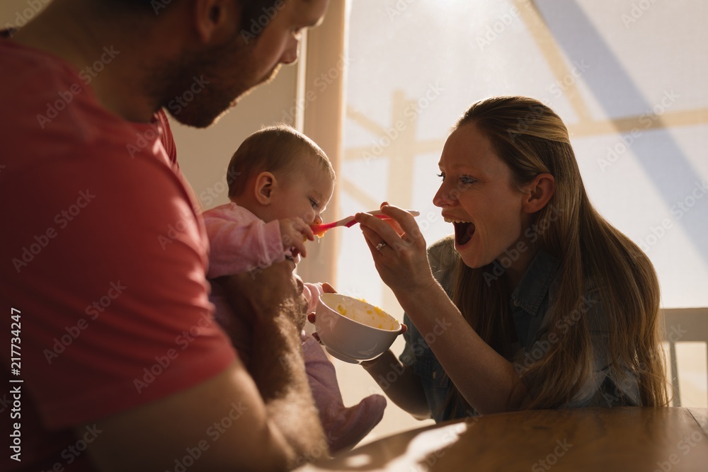 Parents feeding their baby boy at home Parents feeding their baby boy at home