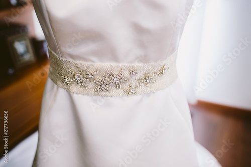 Detail of a white and elegant wedding dress.