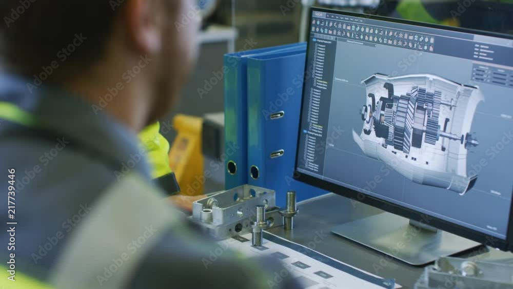 Close-up Back View of the Mechanical Engineer Designing 3D Engine Model on Personal Computer. Professional Working At the Factory.