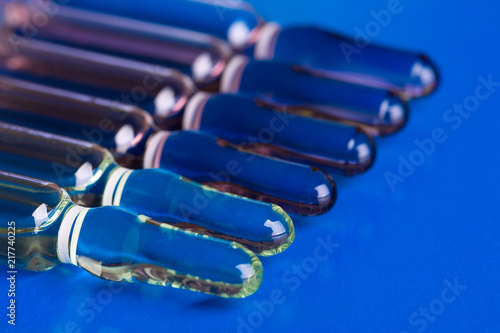 Glass ampoules lying in a row on a blue background