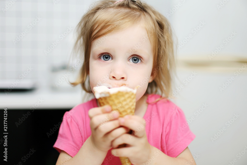 Lovely little toddler girl eats ice-cream Lovely little toddler girl eats ice-cream