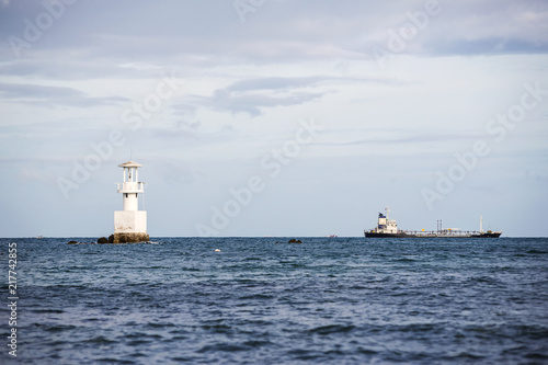 Lighthouse and ship in the sea.