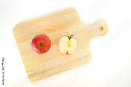 red apple on wood plate in white background