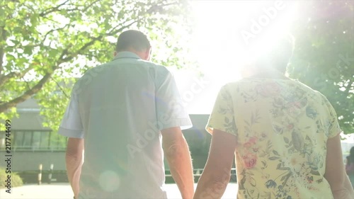 Back view slow motion steady cam view of an active senior caucasian tourist couple walking in london backlit by the sun themes of sightseeing active seniors direction on the move