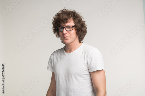 Portrait of serious stylish student man in glasses and casual outfit on white background © satura_