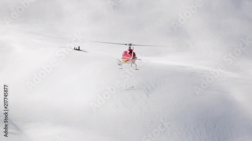 Helicopter as part of a heli ski operation in the Himalayas. Red helicopter in Kashmir, India. Big mountains, lot's of snow and trees.