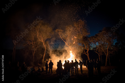 Tela A large group of people gathering around a bonfire