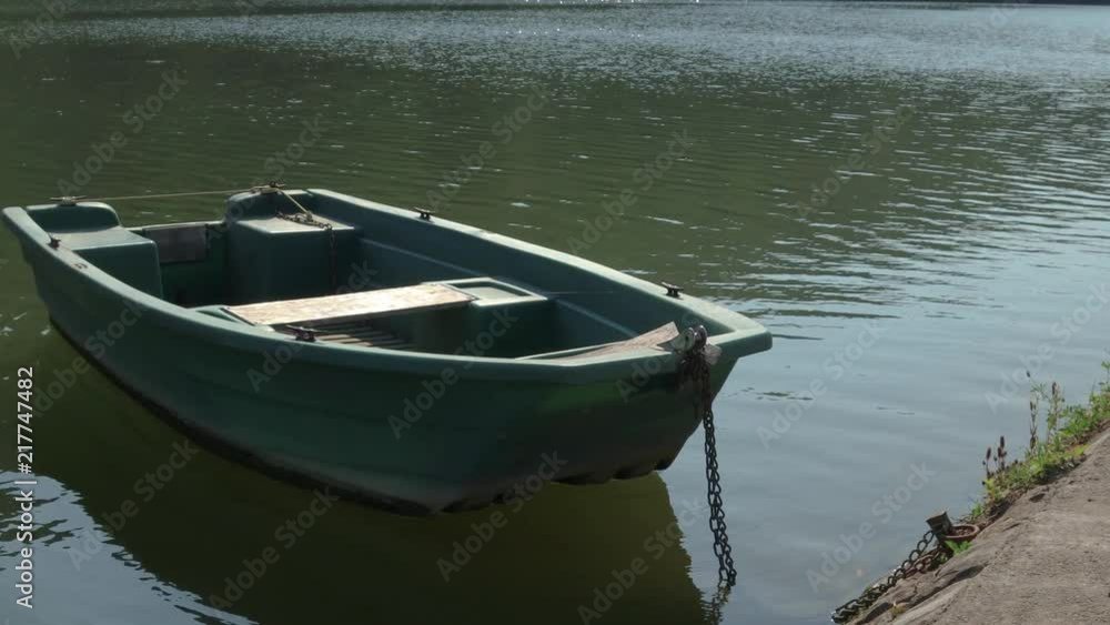 A lonely boat tied to the dock, along the Meuse river, Belgium A lonely boat tied to the dock, along the Meuse river, Belgium