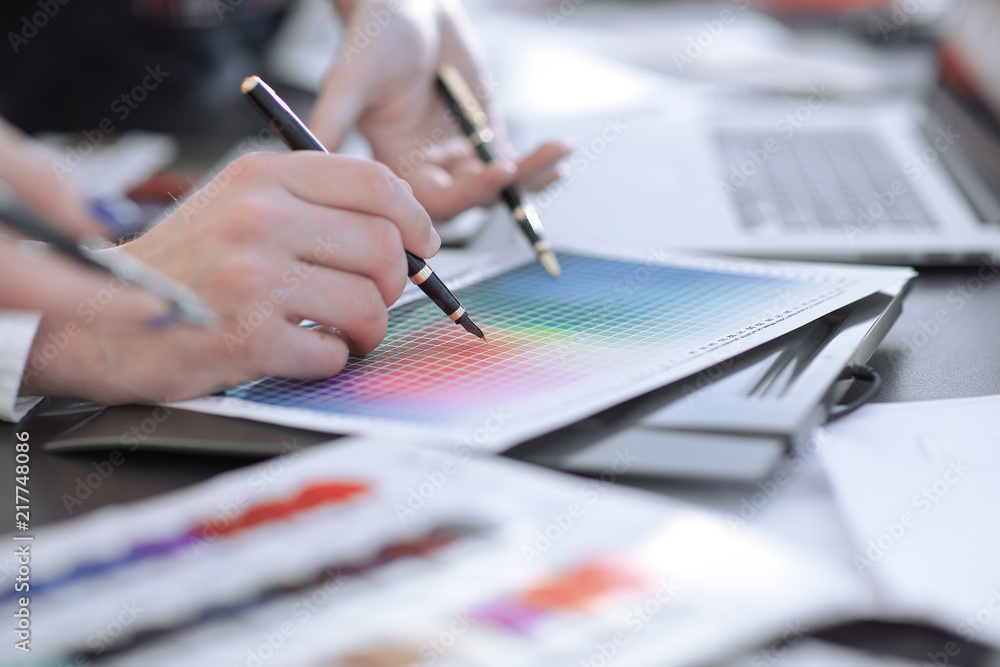 close up.a group of designers discussing the blueprint at the table