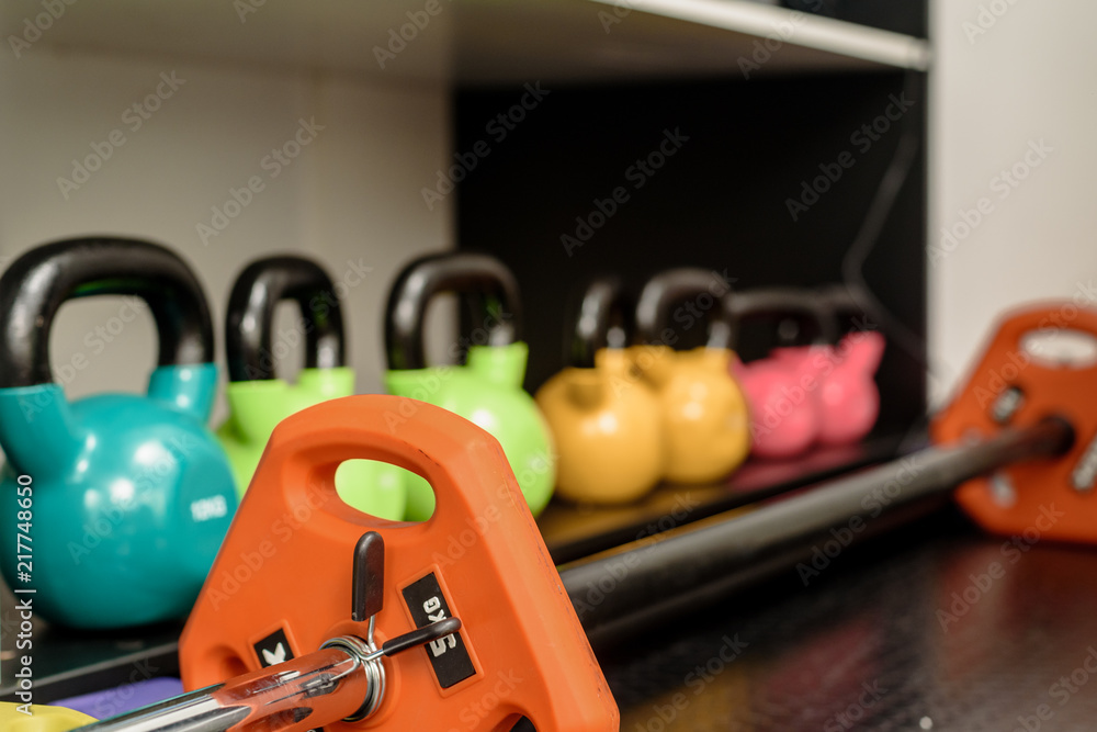 Set of colorful iron modern kettlebbells on rack in gym Set of colorful iron modern kettlebbells on rack in gym