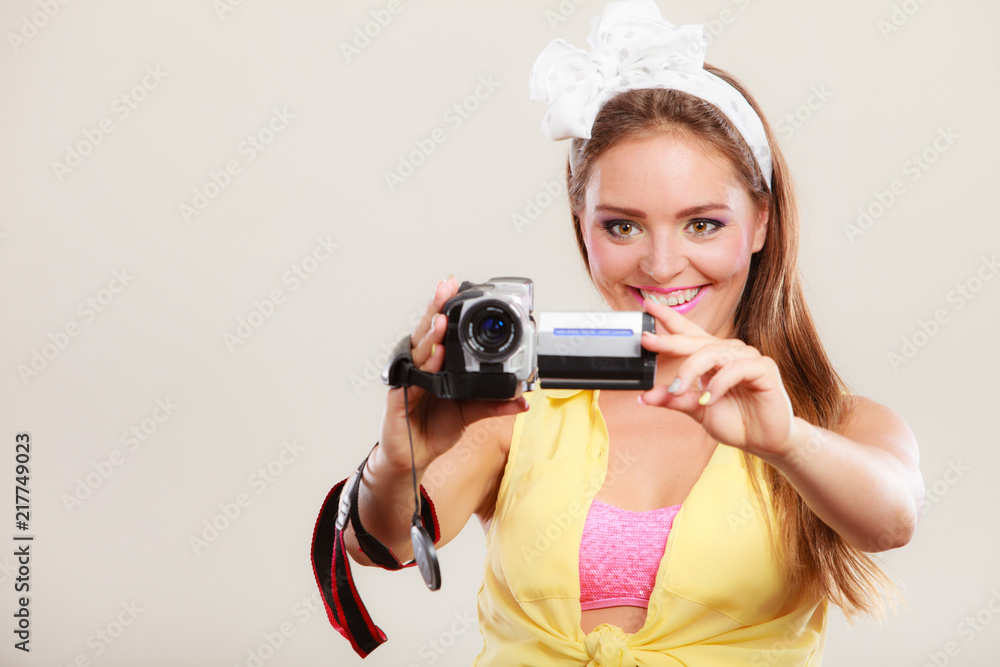 Fototapeta premium Happy pin up girl woman filming with camcorder.