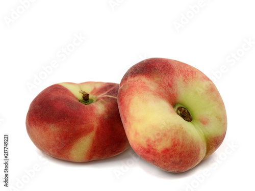 Prunus Persica, two flat peaches isolated on a white background