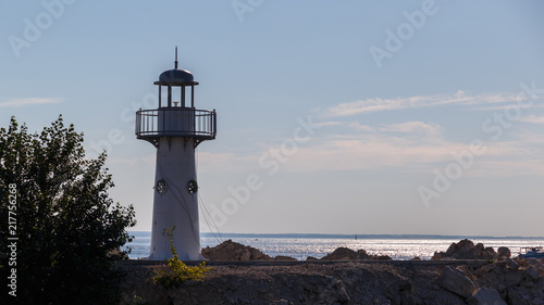 White lighthouse on the background of calm sea in the afternoon