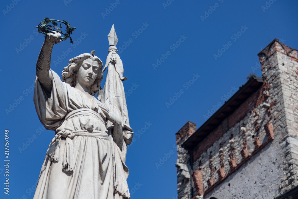 Fototapeta premium Monument against the blue sky (a woman holding a wreath in his hands)
