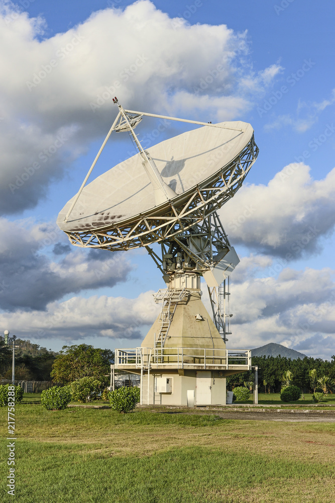 Satellite control antenna with blue sky and clouds, vertical