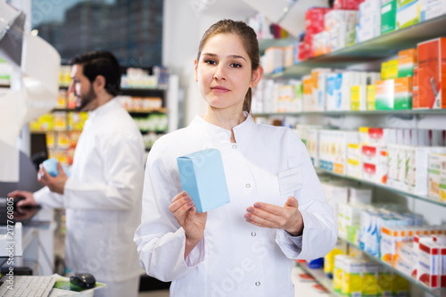 Woman pharmacist standing in drugstore Free Download Woman pharmacist standing in drugstore - GFXLoad