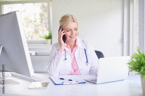 Female doctor consulting with her patient on mobile phone