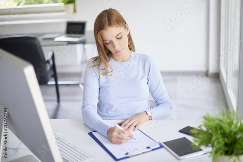 Young professional woman making notes