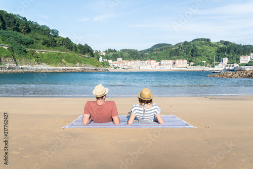 Pareja de enamorados pasando un día soleado en la playa de Saturraran en Euskadi, España photo