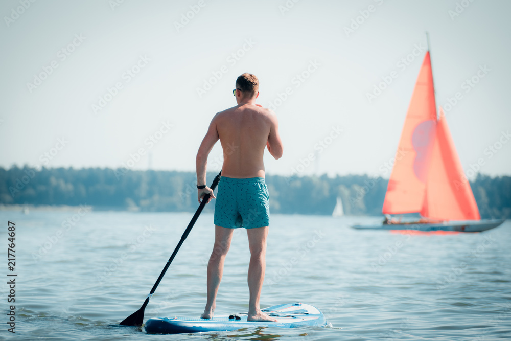 Man standing on a raft with an oar