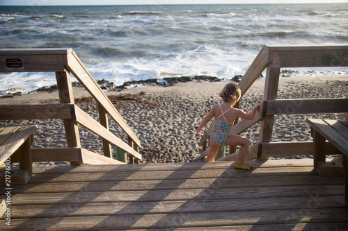A child climbs down a beach stairway. 