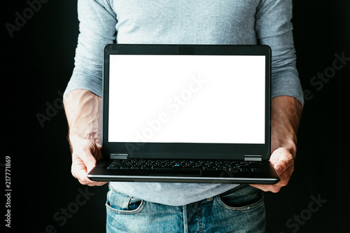 online income. work remotely and earn money from home. internet technology and modern business trends concept. man holding a laptop with empty white screen.