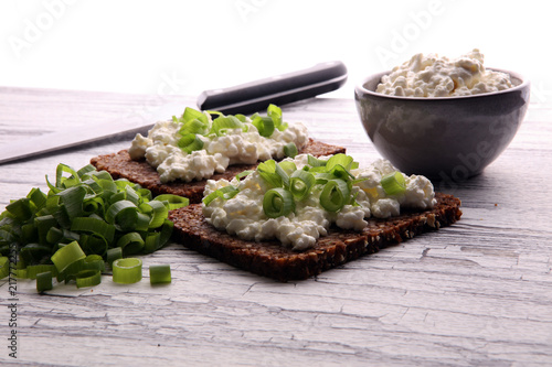 Cream Cheese on a slice of bread topped with fresh green onions or spring onions