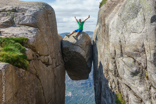 Man jumping over Kjeragbolten in Norway. Kjerag photo