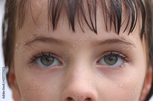Close up of a set of young green eyes looking up in thought