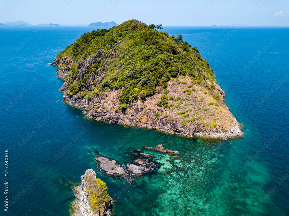 Aerial drone view of a beautiful remote tropical island surrounded by coral reef
