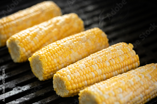 Canvas Print Raw corn on the cob cooking on a barbecue
