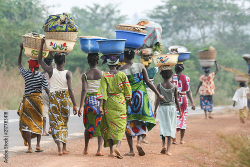 Fotografie, Obraz African women carrying bowls on their heads, Benin, Africa