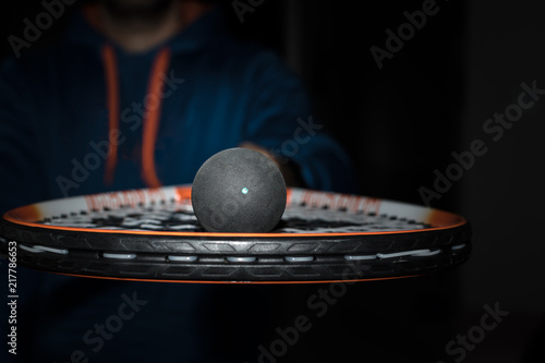 Single dot squash ball on the strings of a racquet photo