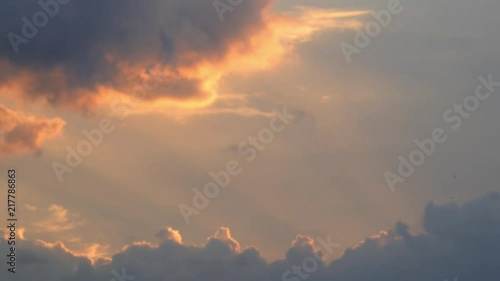 Blue clouds inlightened by the orange rays of the setting sun